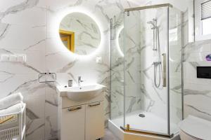 Un baño con ducha, lavabo y espejo. en Domki Adek 2, en Władysławowo 25 fotos más