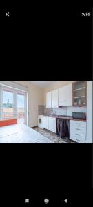 a kitchen with white cabinets and a large window at Casa Melina e enzo in Agnone Bagni +32 photos
