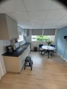 een keuken en eetkamer met een tafel in een kamer bij 't Vakansie'uus in Serooskerke
