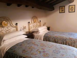 1 dormitorio con 2 camas con sábanas blancas en Agriturismo Casale Tozzetti, en Norcia