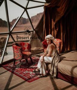 a woman sitting on a bed in a tent at Desert relax camp in Wadi Rum