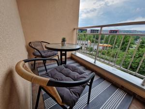 a balcony with a table and chairs and a large window at Apartment Pacifik Lux & Private Garage in Sarajevo