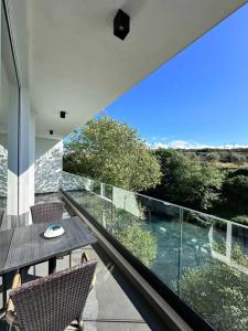 a house with a balcony with a table and chairs at Lumi Residence Apartment 2 in Sarandë