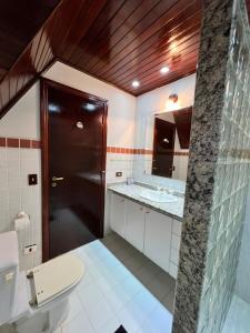 y baño con aseo y lavamanos. en Vila husky pousada, en Campos do Jordão