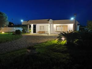 uma pequena casa branca à noite com luzes em Villa Talìa em Marsala