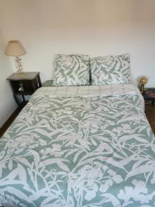 een bed met een blauw en wit dekbed erop bij Logement Colmar centre avec Parking in Colmar