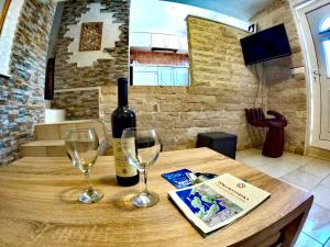 una mesa con una botella de vino y dos copas en Apartments Obradovic, en Krasići