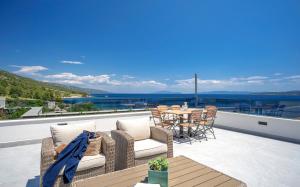 patio con mesa y sillas en el balcón en Exclusive Seafront Suite with jacuzzi, en Zavala