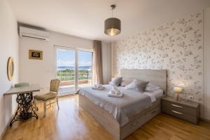 a bedroom with a large bed and a window at Villa Oasis in Kastel Novi