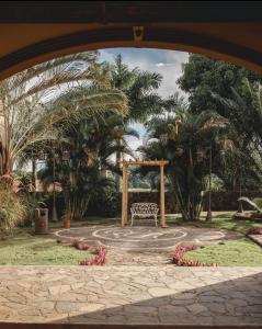 eine Bank in einem Park mit Bäumen und Palmen in der Unterkunft Hotel El Reith Lake in Granada