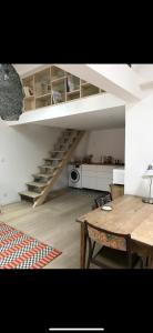 a living room with a wooden table and a staircase at Suite Bergame in Caluire-et-Cuire