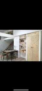 a living room with a table and a staircase at Suite Bergame in Caluire-et-Cuire