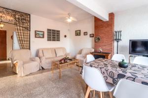 een woonkamer met een bed en stoelen en een televisie bij Les Tonyines 68 apartamento con vistas y terraza in Llança