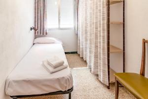 een kleine kamer met een bed en een bureau bij Les Tonyines 68 apartamento con vistas y terraza in Llança
