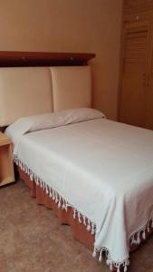 Un dormitorio con una gran cama blanca con cabecero. en Casa campo 2 habitaciones, en Tequisquiapan