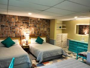 a bedroom with two beds and a brick wall at Hotel Cuellar in Tula de Allende