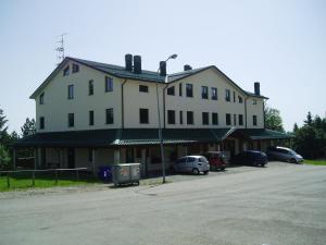 a large white house with cars parked in front of it at Normena Mountain Residence in Tizzano Val Parma