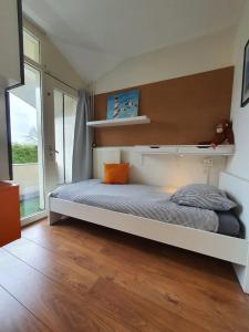 a bedroom with a bed and a large window at Kust Geluk in Schoorl