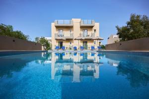una gran piscina con un edificio en el fondo en Acropolis Apartments, en Hersonissos