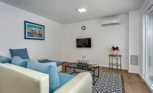 a living room with a blue couch and a tv at Apartman Anavi in Sveti Vid-Miholjice