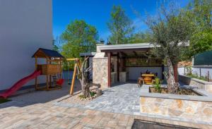 a backyard with a playground and a play structure at Apartman Anavi in Sveti Vid-Miholjice