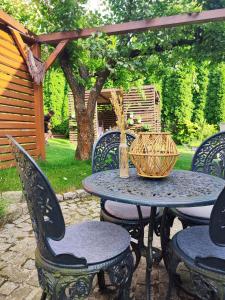 una mesa de patio con sillas y una cesta. en Lawendowo- sauna jacuzzi domki w ogrodzie i apartamenty w kamienicy, en Sandomierz