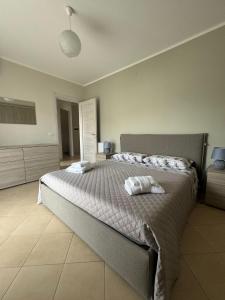 a bedroom with a large bed with two towels on it at DENIA'S HOME in SantʼEufemia Lamezia