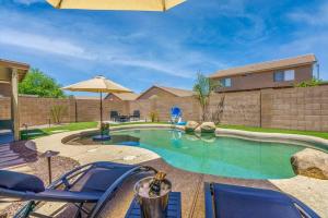 a swimming pool with chairs and an umbrella at Great location near shopping & entertainment in Litchfield Park