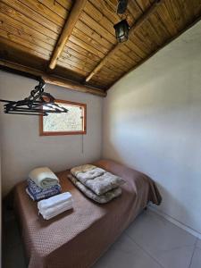 a small room with a bed with towels on it at Chalés Vila Real - Tranquilidade na Serra de Carrancas - Piscina com uma vista espetacular do Pôr do Sol in Carrancas