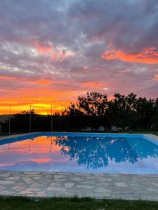 a sunset over a swimming pool with the sky at Wineyards Salin in Turda