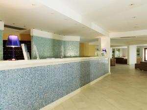 a lobby with a tile counter with a purple lamp at Porto Kaleo Resort in Steccato