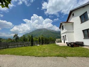 a white house with a mountain in the background at Visitor Yard in Plav