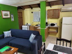 a living room with a blue couch and a kitchen at On the Beach in Black Rock