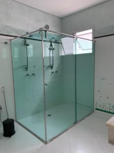 a glass shower stall in a bathroom at Casa em Guarujá-Jardim Acapulco in Guarujá