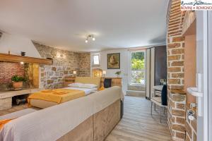 sypialnia z dwoma łóżkami i ceglaną ścianą w obiekcie Studio Tommy w Rovinj