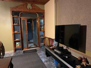 a living room with a large flat screen tv at Njombe Cozy House in Njombe
