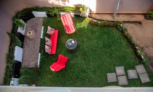 カンパラにあるThe Mbuya Residenceの赤い家具と芝生のある裏庭の景色