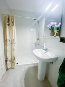 a white bathroom with a sink and a shower at Tarifa Ocean Side Tu espacio de descanso in Tarifa