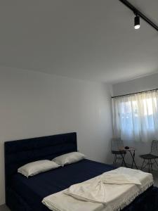 a bedroom with a blue bed and a window at Sunny Rentals in Vlorë