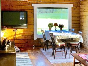 a dining room with a table and a large window at Holiday home DALS-LÅNGED in Dals Långed