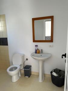 a bathroom with a toilet and a sink and a mirror at Sunny Rentals in Vlorë