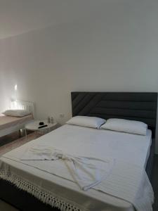 a bedroom with a large bed with white sheets at Sunny Rentals in Vlorë