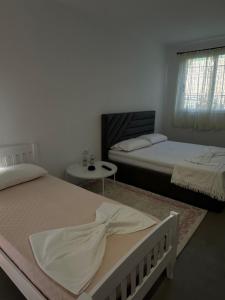 a bedroom with two beds and a table and a window at Sunny Rentals in Vlorë