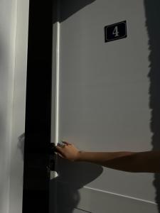 a person opening a door with their hand on it at Sunny Rentals in Vlorë