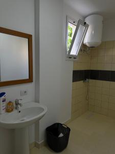 a bathroom with a sink and a shower with a window at Sunny Rentals in Vlorë
