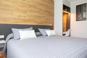 Hostal O'Cruceiro في O Pino : غرفة نوم بسرير كبير وبجدار خشبي