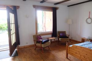 a bedroom with a bed and two chairs and a table at Hof Welzin - Stellmacherei in Passow