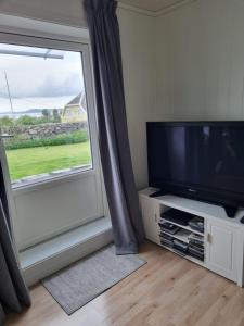 een woonkamer met een flatscreen-tv en een raam bij Not far from famous Pulpit Rock and Stavanger in Strand