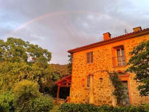 A Casa là - l'Aiola في Paciano: منزل من الطوب البرتقالي مع قوس قزح في السماء