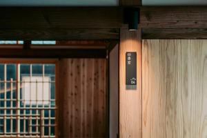 a close up of a wooden door with a sign on it at Ikeda Ryokan - Vacation STAY 79298v in Nishinoomote